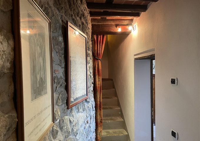 Stenen gang met originele trap in een Toscaans dorpshuis